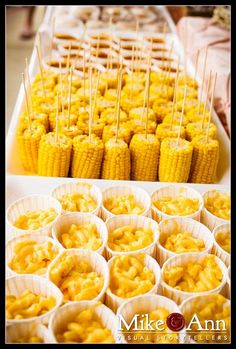 corn on the cob and cupcakes are arranged in paper cups for display