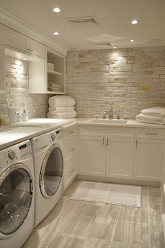 a washer and dryer in a small room with white cabinets on the walls