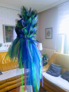 a living room filled with furniture covered in blue and green feathers on top of it