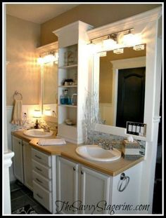 a bathroom with two sinks and a large mirror above the sink is lit by lights