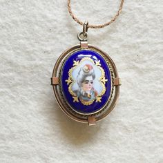 "Victorian Enamel Pendant French Champleve Enamel Here is an lovely original Victorian era pendant of rolled gold with dark blue and champlevé enamel with center painted figure of a lovely young woman with a big hairdo, reverse side is lovely turquoise blue enamel. Typically French in origin for sure! There is some lovely cannetile wirework surrounding the front of the pendant. Pendant measures 1 5/8\" in length with bale. I've shown it with a brand new 15\" gold filled chain - would look lovely Portrait Necklace, Vitreous Enamel, Gold Bond, Velvet Ribbon, Gold Filled Chain, Victorian Era, Antique Collection, Young Woman, Turquoise Blue