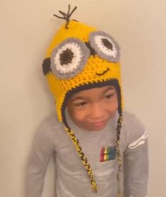 a little boy wearing a yellow hat with eyes