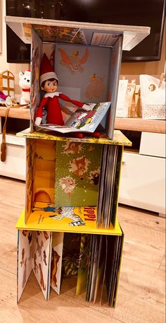 the elf is sitting in the open book case