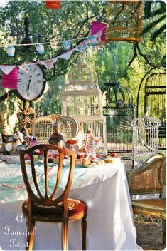 the table is covered with many different items and birdscages hanging from it's branches