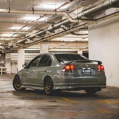 a car parked in a parking garage with its lights on and it's rear end showing