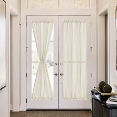 an entry way with two doors and white curtains