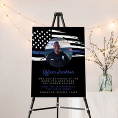 a sign with an image of a police officer on it next to a vase and string lights