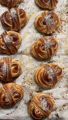 freshly baked pastries on parchment paper covered in powdered sugar