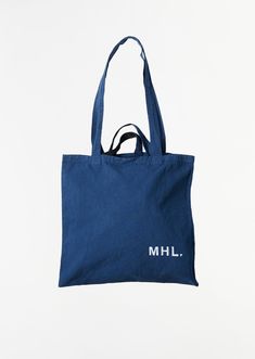 MHL by Margaret Howell workwear blue tote bag in linen cotton twill. Features shoulder straps and top handles. Finished with white logo on bottom right corner.  

Also available in: Mahogony. 

Sizing: One Size. Measures approximately: 17 H x 18 W in. 

Color: Workwear Blue. 75% Cotton, 25% Linen. Imported. 

FW24MHL02 Blue Cotton Canvas Bag With Pockets, Everyday Navy Cotton Canvas Bag, Navy Cotton Canvas Bag For Everyday, Navy Cotton Tote Bag, Everyday Blue Cotton Bag, Everyday Blue Cotton Bags, Blue Double Handle Canvas Bag For Everyday, Everyday Blue Cotton Canvas Bag, Blue Cotton Canvas Travel Bag