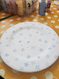 a white plate sitting on top of a table next to candles and markers in front of it