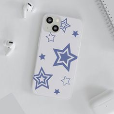 an iphone case with blue stars on it next to ear buds and headphones,