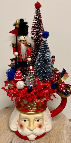 a nutcracker themed christmas arrangement in a coffee cup