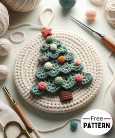 a crocheted christmas tree ornament on a table with yarn and scissors