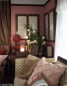 a living room filled with lots of furniture and flowers on the window sill in front of them