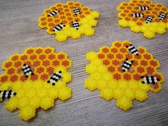 four pieces of bead art with bees on them