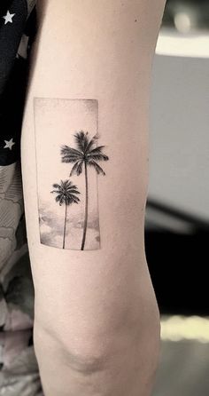 a small palm tree tattoo on the arm