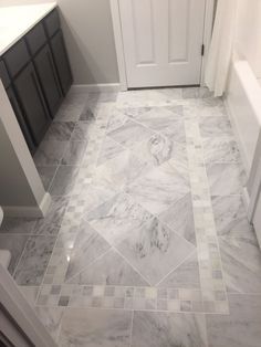 a bathroom with white and grey marble flooring