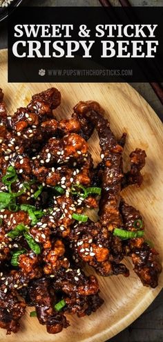 sweet and sticky crispy beef on a wooden platter with sesame seed sprinkles