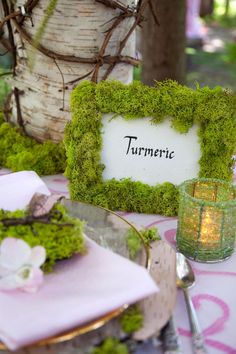 the table is set with moss covered place mats and napkins for guests to eat