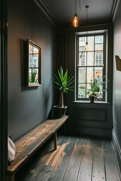 a wooden bench sitting in front of a window next to a potted green plant