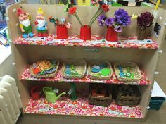 a shelf filled with lots of toys and flowers