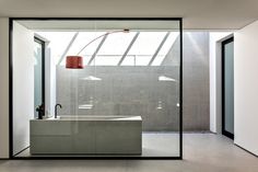 an empty bathroom with a large tub in the middle and a red lamp hanging from the ceiling