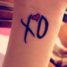 a small wrist tattoo with the letter q on it's left arm and a heart in the middle