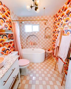 a bathroom with pink and orange decor on the walls