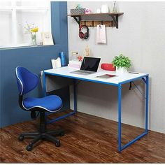 a computer desk with a laptop on it in front of a blue wall and wooden floor