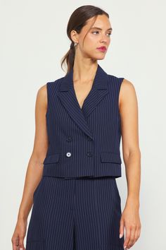 Menswear-inspired tailoring, updated for the warmer months. Done in classic pinstripes, this double-breasted vest features a sleeveless silhouette with peak lapels and flap pockets. Go for a summer take on the power suit by pairing it with our pinstriped jumpsuit or the matching pants. •Sleeveless •Double breasted •Peak lapels •Flap pockets •Buttons fastenings Item Number: 25798 SELF: 33% RAYON 63% POLYESTER 4% SPANDEX LINING: 95% POLYESTER 5% SPANDEX Pinstripe Vest, Double Breasted Vest, Pinstripe Pattern, Formal Shirt, Crisp White Shirt, Sports Skirts, Sport Dress, Matching Pants, Menswear Inspired