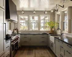 a kitchen with white cabinets and black counter tops, along with an area rug on the floor