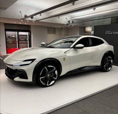 a white sports car on display in a showroom