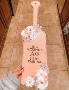 a person holding up a sign with flowers on it