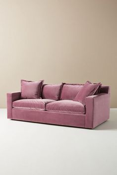 a pink couch sitting on top of a white floor