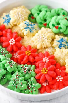 a white bowl filled with decorated cookies on top of a table