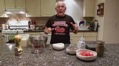 an older man standing in front of a kitchen counter with bowls and measuring cups on it