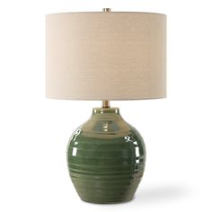 a green ceramic lamp with a beige shade on the base and a white linen lampshade