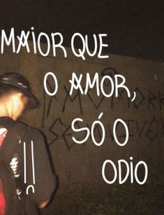 a man standing next to a wall with writing on it