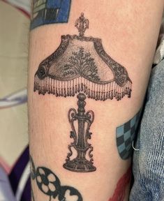 a black and white photo of a lamp on someone's leg, with skulls around it