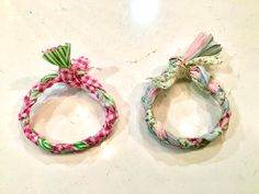 two bracelets with bows are sitting on a counter top, one is pink and the other is green