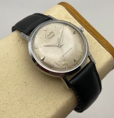 This 1960's Creation "Mastership" watch is very unique, with its geometrically textured silver dial patterned in such a way to give an almost 3-D sphere appearance.  Its indices are a combination of applied arrows and zigzag lines, adding further visual appeal to an already impressive display.  It is a manual winding, shock resisting timepiece, with a 17 jewel Swiss made movement that is winding, setting, and keeping time excellently.  The printed wordmarks on the dial remain in like new appeara Luxury Vintage Manual Winding Watches, Vintage Engraved Watch For Business, Vintage Engraved Business Watch, Vintage Silver Business Watch, Vintage Silver Watches For Business, Silver Vintage Business Watches, Vintage Silver Watch Accessories For Business, Retro Silver Watch Accessories For Formal Occasions, Zigzag Line