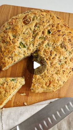 a piece of bread is cut into pieces on a cutting board with a knife next to it