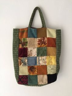 a multicolored patchwork tote bag hanging on a wall with white background