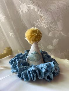 a small blue and white hat with a yellow pom - pom on top