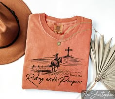 Comfort Colors® Religious Shirt, Riding with Purpose Shirt, Christian Comfort Colors Shirt, Western Graphic Tee, Cowgirl Shirt, Faith Shirt, Bible Verse Shirt, Jesus Is King Shirt ###Sizing and Color Guidelines### We use Comfort Colors Heavyweight brands t-shirts for all the listings where you see Comfort Colors in the title. The shirts are Unisex size. They are meant to be loose-fitting, so ordering one size smaller is recommended if you want a tighter fit. Each of our shirts is meticulously crafted to your specifications, making returns or exchanges impractical. Prior to placing your order, please consult our comprehensive color and size charts to ensure a flawless fit. Should you require assistance with sizing or color selections, feel free to reach out to us for clarification ###HOW TO Western Women Tshirts, Cute Western Tees, Western Christian Shirts, Western T Shirts For Women, Western Tshirt Designs, Western Tee Shirts, Scripture Shirts, Western Shirts For Women, Western T Shirts