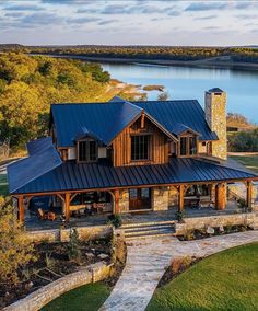 an aerial view of a house with a lake in the background