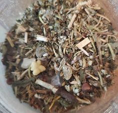 a bowl filled with lots of different types of herbs and spices on top of a table