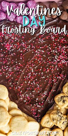 a chocolate frosted heart shaped cake surrounded by cookies