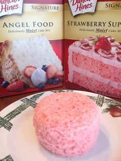 two boxes of angel food and a pink cake on a white plate with strawberries