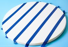 a white and blue striped coaster on a blue background with some blue ribbon around it